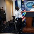 Cleaning staff disinfect the lectern in the White House Press Briefing Room