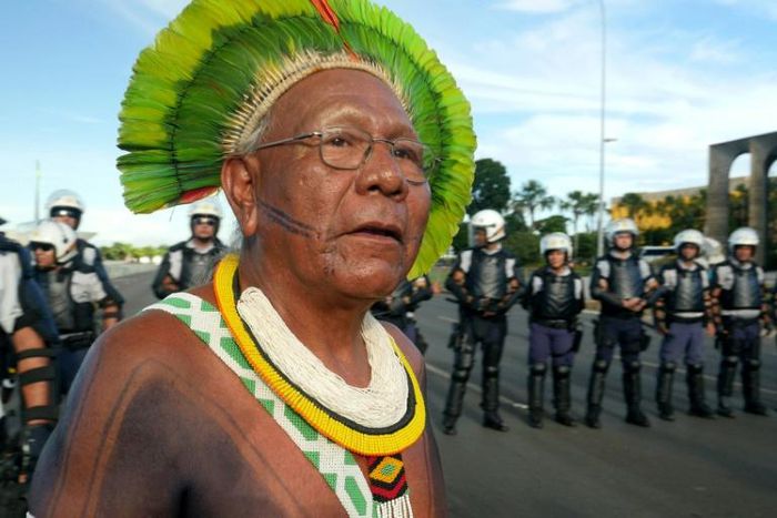 Indigenous chief Paulinho Paiakan, shown here standing in front of riot police in Brasilia, Brazil, on April 27, 2017 has died after contracting the new coronavirus, activists say