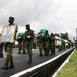 Ivory Coast soldiers carry coffins and pictures of their comrades killed in a brazen jihadist attack last month
