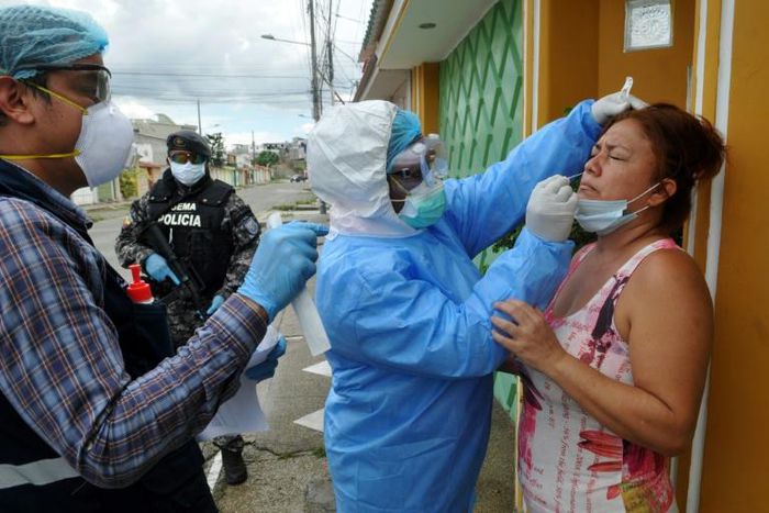 Health ministry personnel test a woman for the novel coronavirus in northern Guayaquil, Ecuador, on April 19, 2020