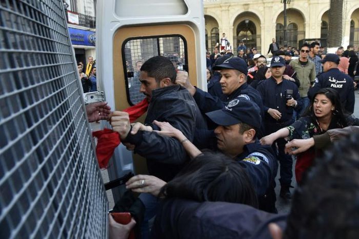 Algerian police detain protesters after a demonstration in the capital Algiers on April 14, 2019