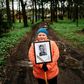 A woman carries a portrait of her grandfather near a monument in a small village outside Moscow dedicated to those who fought in World War II