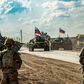 US soldiers stand along a road across from Russian military armored personnel carriers near the village of Tannuriyah in Syria's northeastern Hasakah province on May 2, 2020