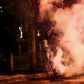 A Lebanese anti-government protester kicks back a tear gas canister fired by security forces during a protest against dire economic conditions in Beirut on Friday night