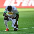 Moenchengladbach's French forward Marcus Thuram takes a knee