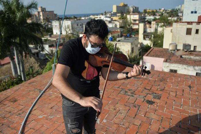 Cuban violinist William Roblejo rehearses on the rooftop of his house in Havana