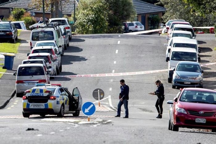 Police officers cordon off an area after the fatal shooting in a residential neighbourhood in Auckland