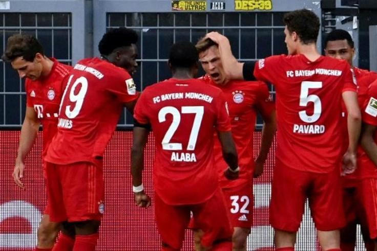 Bayern Munich midfielder Joshua Kimmich (C) celebrates scoring the winning goal at Borussia Dortmund.