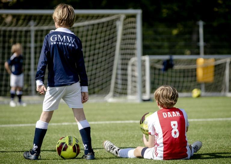 Dutch children play football during the first reopening day of youth training camps in the Netherlands after the coronavirus covid-19 outbreak in The Hague, on April 29, 2020