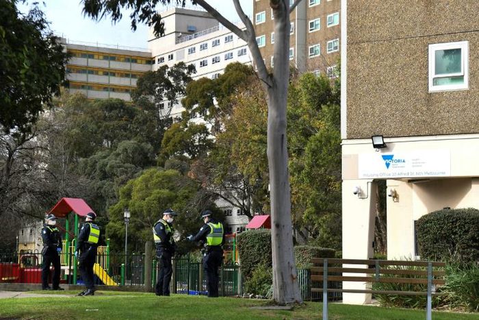 Police stand guard outside a public housing estate locked down in Melbourne due to a spike in coronavirus cases