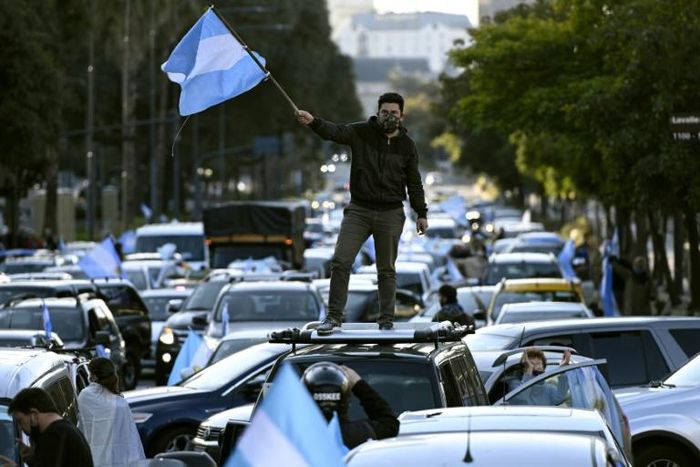 A man waves the Argentine flag during a protest against President Alberto Fernandez's health policies during the coronavirus pandemic in Buenos Aires on July 9, 2020