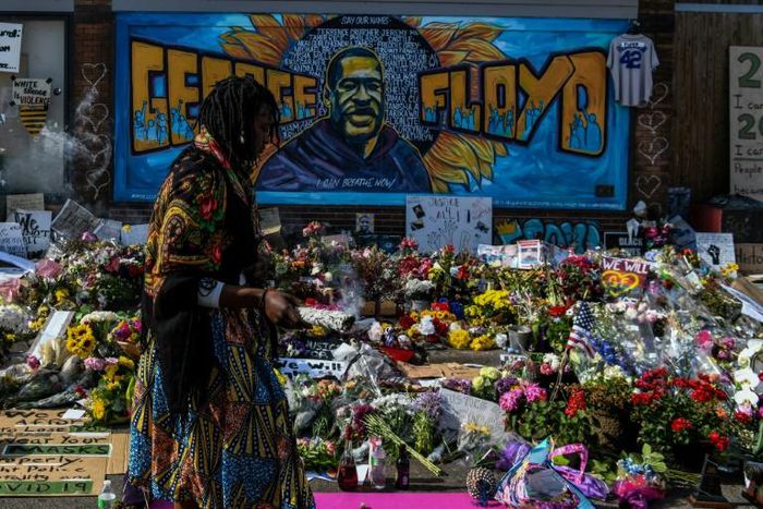 A woman burns sage and offers prayers as she pays her respects at a makeshift memorial in honor of George Floyd, on June 3, 2020 in Minneapolis, Minnesota