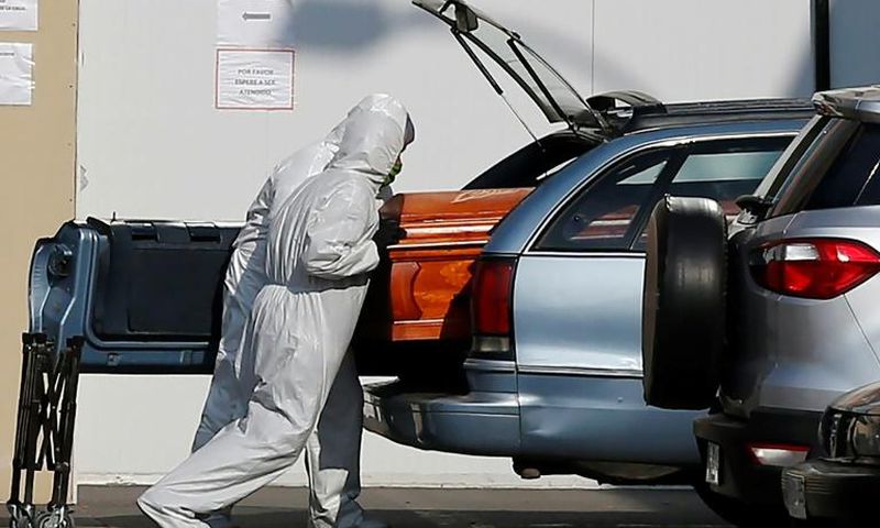 Employees of a Santiago funeral parlour load a coffin of a person who died of COVID-19 into a relative's vehicle outside the San Jose Hospital -- the Chilean capital has borne the brunt of the country's outbreak