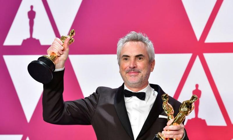 Alfonso Cuaron poses with his Oscars at the Academy Awards on February 24, 2019