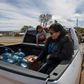 Members of the Larson family who have no running water in their home, collect water from a distribution point in the Navajo Nation town of Thoreau