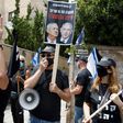 An Israeli protester holds a placard with a picture of Prime Minister Benjamin Netanyahu and his former rival Benny Gantz in Jerusalem