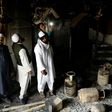 Muslim men check the interior of a partially burnt mosque on March 1, 2020 after communal riots in New Delhi