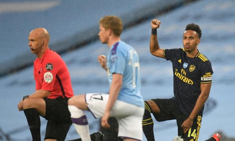 Arsenal striker Pierre-Emerick Aubameyang (R) takes a knee alongside Manchester City's Belgian midfielder Kevin De Bruyne (C) and Referee Anthony Taylor (L)