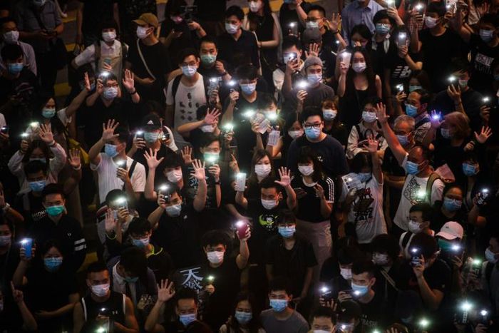Hong Kongers hold up their mobile phones during a rally in Causeway Bay on June 12 to mark the one-year anniversary of the start of major pro-democracy protests in the city