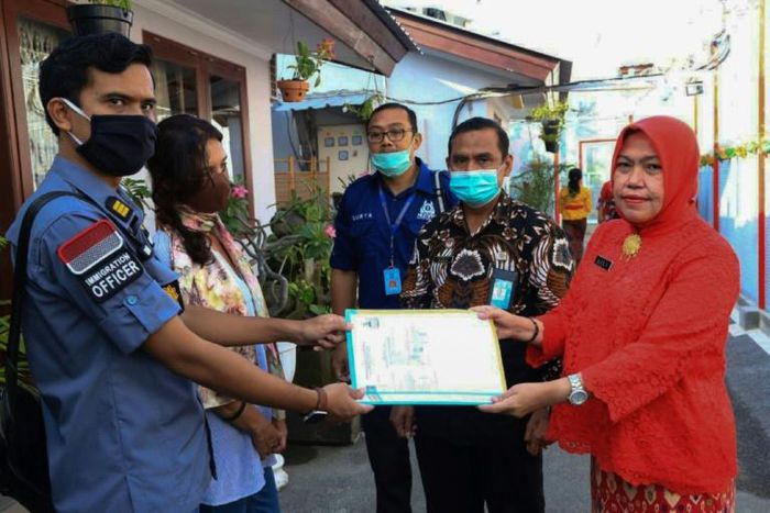Australian Sara Connor (2nd L) with officers outside Kerobokan prison in Bali on Thursday