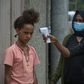 Ethiopian health ministry take a girl's temperature during door-to-door screening in Addis Ababa