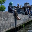 People over 65 wearing protective face masks sit and enjoy the sun on the Bosphorus in their first trip outdoors since a tough coronavirus lockdown was imposed nearly two months ago