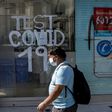 A man walks past a pharmacy where COVID-19 tests are conducted in  Santiago, Chile