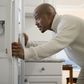 African man looking in refrigerator