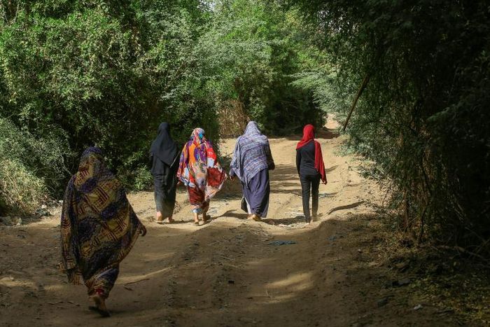 Sudanese women walk in the capital Khartoum's district of Jureif Ghar