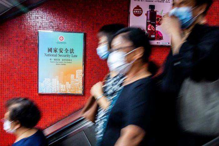A government advertisement (L) promoting China’s national security law is displayed inside an MTR train station in Hong Kong