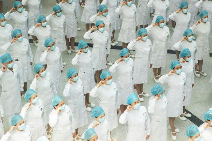 Nurses recite an oath on International Nurses Day at Tongji Hospital in Wuhan, China, where authorities have ordered the entire population be tested for the coronavirus