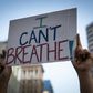 A demonstrator raises a sign during a protest against the death of George Floyd who died on May 25 in Minneapolis whilst in police custody, along a street in Oakland, California on June 3