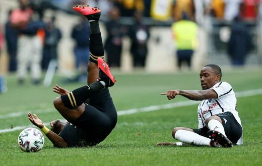George Maluleka (L) of Kaizer Chiefs tumbles after colliding with Mthokozisi Dube (R) of Orlando Pirates in a match between the biggest South African Premiership crowd-pullers