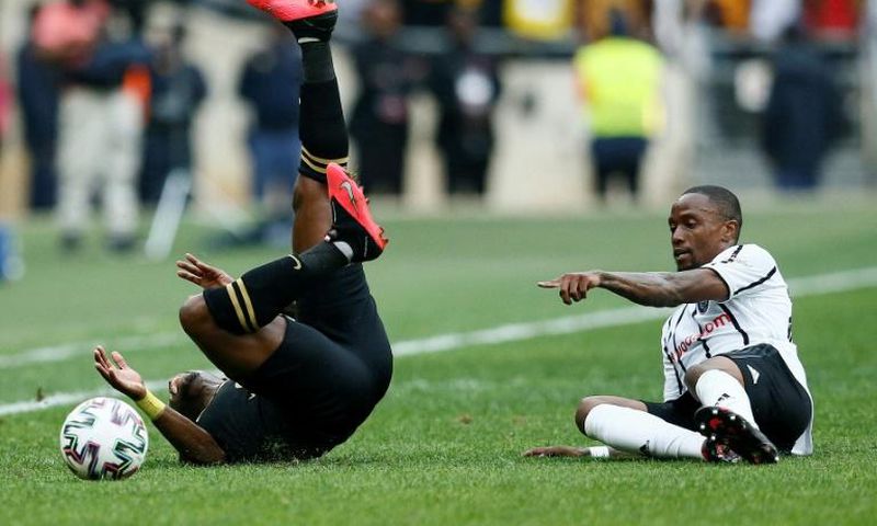 George Maluleka (L) of Kaizer Chiefs tumbles after colliding with Mthokozisi Dube (R) of Orlando Pirates in a match between the biggest South African Premiership crowd-pullers