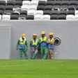 Workers gather at Qatar's al-Bayt stadium ahead of the coronavirus pandemic which has claimed its first victim among the World Cup workforce