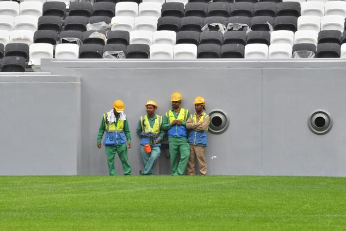 Workers gather at Qatar's al-Bayt stadium ahead of the coronavirus pandemic which has claimed its first victim among the World Cup workforce