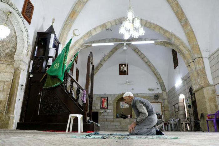 A man prays at Al-Khadra mosque in the old quarter of the West Bank town of Nablus; The Palestinian Authority has imposed a night and weekend curfew on the occupied West Bank for the next 14 days due to COVID-19