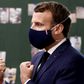 President Emmanuel Macron sporting a mask adorned with the red, white and blue of the French flag during a school visit.