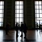 UN Human Rights Council delegates are seen in silhouette outside of the assembly hall during a session in Geneva in March 2020