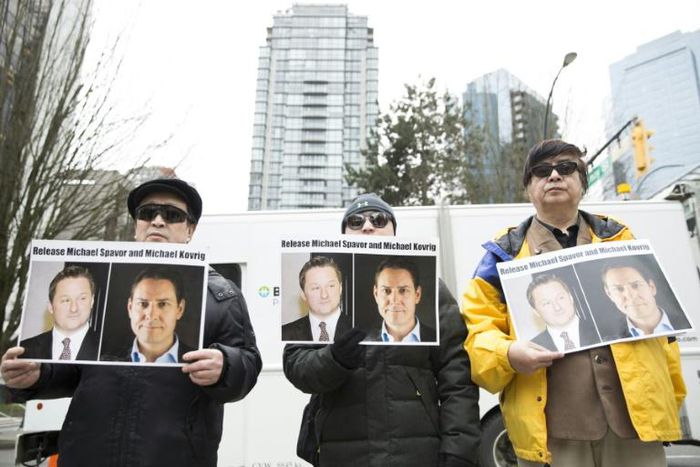 Protesters in Vancouver hold photos of Michael Spavor and Michael Kovrig. The pair have now been held in detention in China for more than 500 days
