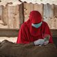 A woman in Djibouti selling khat leaves, a mild stimulant, wears a mask and gloves to ward off the COVID-19 illness