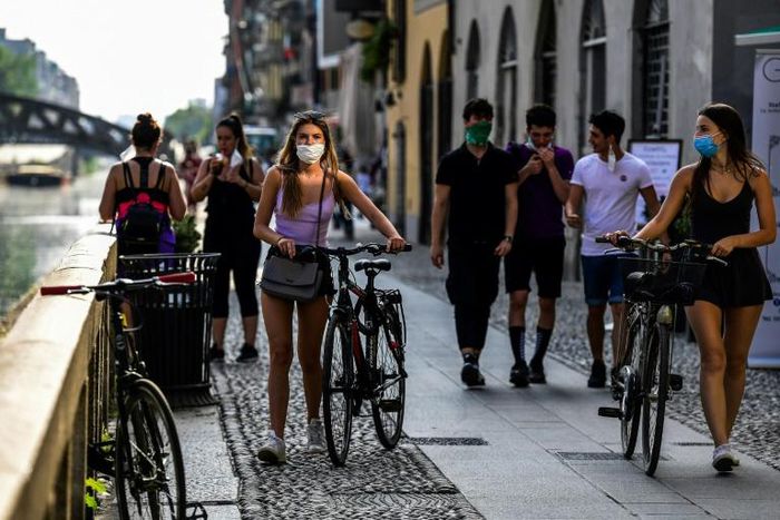 People stroll along the Navigli canals in Milan where police were on patrol to ensure they respected social distancing norms amid fears of a coronavirus resurgence as Italy, one of the worst affected country, eases its strict lockdown rules