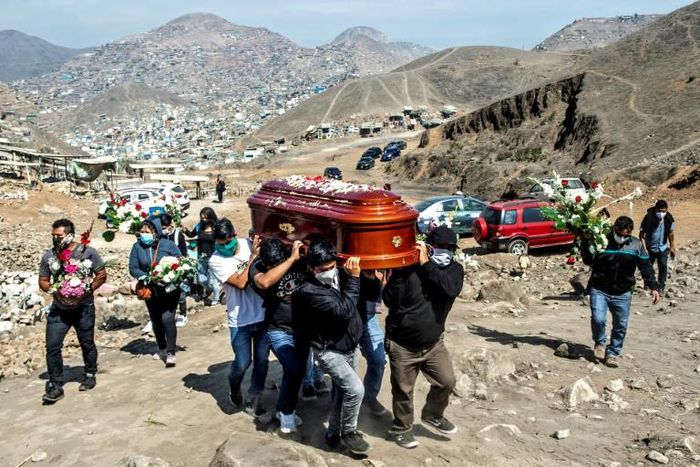 Relatives carry the coffin of a suspected COVID-19 victim at the Nueva Esperanza cemetery, one of the largest in Latin America, in the southern outskirts of Lima -- Peru has lost at least 170 police officers to the disease