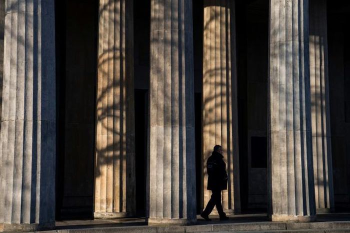 A guard walks past the columns of a memorial in Berlin that will figure in VE day ceremonies