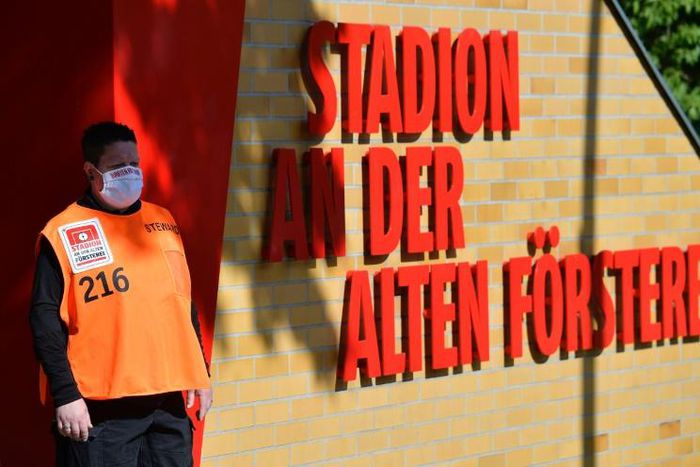 On guard: A volunteer wearing a face mask stands next to the entrance to the Alten Foersterei stadium prior to the Bundesliga match between Union Berlin and Bayern Munich
