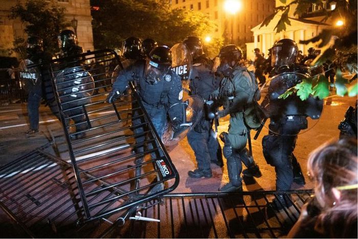 Police charge a barricade in the street during a demonstration against the death of George Floyd near the White House