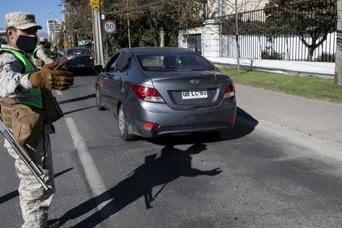 Soldiers stop cars at a checkpoint in Santiago, amid mandatory total quarantine due to the new coronavirus pandemic