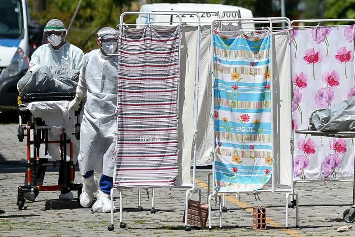 Healthcare workers in protective clothing transport the body of a COVID-19 victim outside Joao Lucio Hospital in Manaus, Brazil, on April 21, 2020