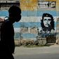 A Cuban man wears a face mask in front of a mural showing revolutionary Che Guevara in Havana -- the coronavirus cases are limited here, but food shortages have become worse as a result of the crisis