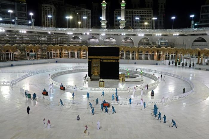 In this file photo taken on April 24, 2020, sanitation workers disinfect the area around the Kaaba in Mecca's Grand Mosque. On Monday Saudi Arabia said it will hold a 'limited' hajj this year due to the coronavirus pandemic